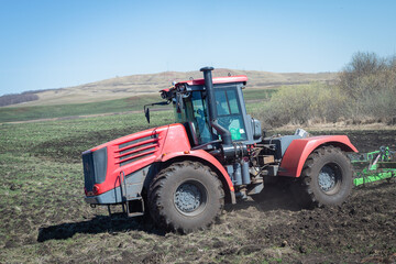 Obraz premium The tractor works in the field in autumn.