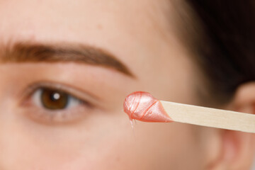 Makeup artist does facial hair removal procedure. Styling and lamination of eyebrows. Woman doing...