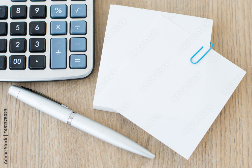 Poster on the desktop a blank white cards to insert text next to a pen and calculator. template.
