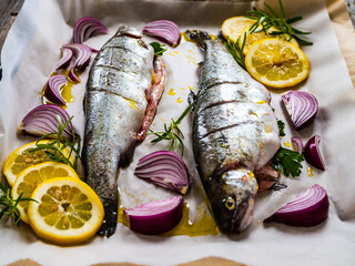Fresh trouts and vegetables on cooking pan prepared to roast