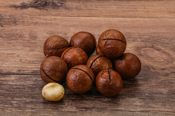 Brown macadamia nut heap over background