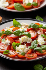 Caprese salad with cherry plum tomatoes, mozzarella cheese and basil. Healthy vegetarian food