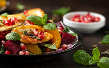 Fried Halloumi Cheese salad with beetroot, orange, pomegranate and pumpkin seeds, red onion, green vegetables. healthy food