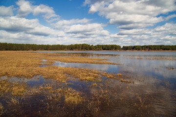 Spring flood on the lake. Beautiful sky with clouds over the lake.