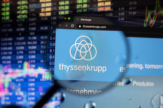 Thyssenkrupp company logo on a website with blurry stock market developments in the background, seen on a computer screen through a magnifying glass