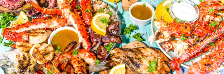 Assortment various barbecue Mediterranean grill food - fish, octopus, shrimp, crab, seafood, mussels, summer diet bbq party fest, with kebab, sauces, light blue sunny wooden background
