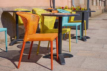 Fototapeta na wymiar Multi-colored chairs on the street terrace of the cafe