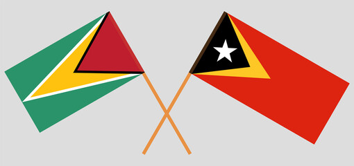 Crossed flags of Guyana and East Timor. Official colors. Correct proportion