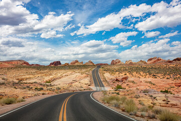 Long winding highway Valley of Fire Nevada, USA. Blue cloudy sky background