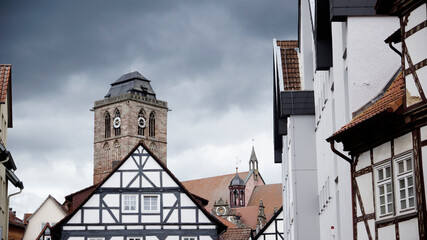 Gotische Stadtkirche in der Altstadt von Bad Hersfeld mit Fachwerkhäusern und wolkigem Himmel