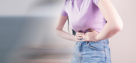 girl lying in bed suffering from stomach pain