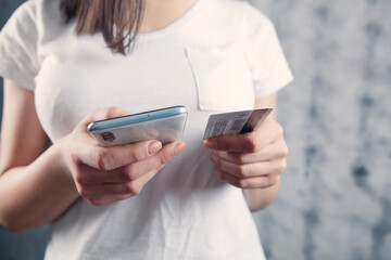 girl holding a phone and a bank card in her hands