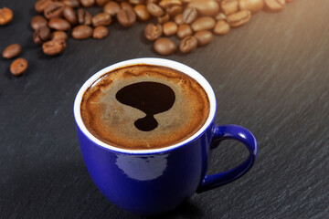 Dark coffee with foam in a blue cup on the background of coffee beans. Top view