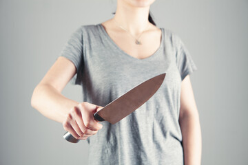 girl holding a kitchen knife to protect herself
