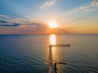 Aerial view of a bridge to sea and a sunset in horizon