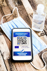 passeport sanitaire Français avec masque et gel sur fond bois