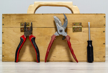 Wooden box with pruner, screwdriver and plier