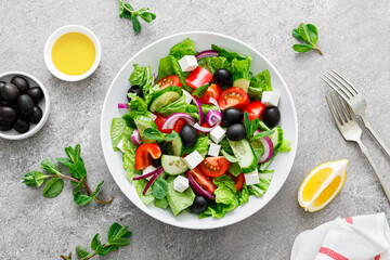 Fresh vegetable greek salad with lettuce, olives and feta cheese, top view