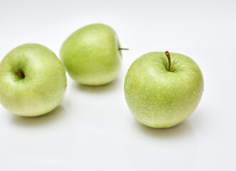 three green apples on a white background