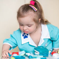Down syndrome in a little girl dressed as a doctor, a disabled child plays role-playing games,...