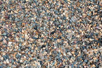 Multicolored surface texture of small crushed stones. Gravel as an industrial background © akintevs