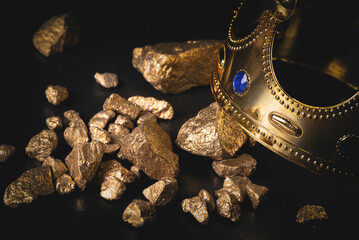 A golden king crown and golden ore on close up abstract background. Royal treasure concept.