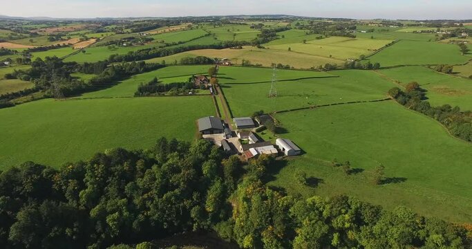 Aerial Panning Over Rural Scottish Farmland With Houses, Trees, And Green Fields Stretching Into The Distant Horizon - Isle of Tiree, United Kingdom