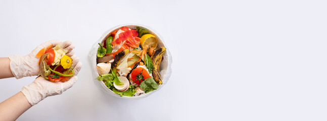 Organic food waste in bowl and in hands on white background top view. Vegetable peelings and food...