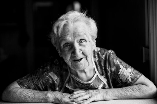 Portrait of senior woman sitting indoor. Black and white photo.