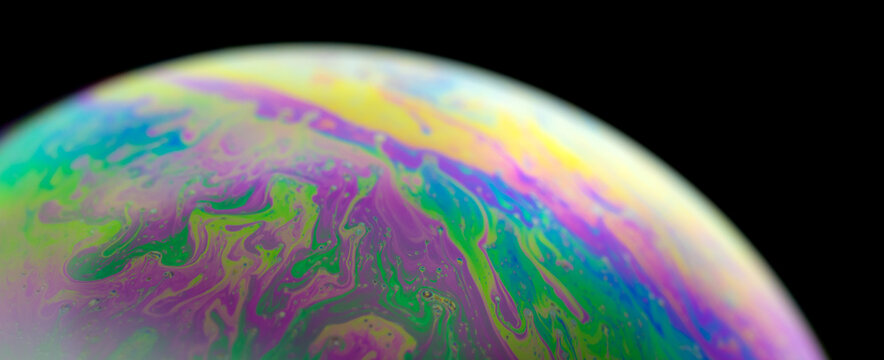 Colourful soap bubble close up. Macrophotography of bubbles. Caused by the interference of light, and creating a dream-like image on the surface of bubbles.