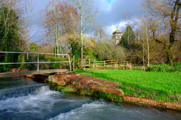 Obraz premium Winter afternoon light on the river Meon at Meonstoke with the church of St Andrew's, Hampshire