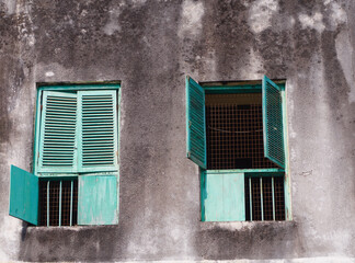View to the two old wooden frame windows on ancient concrete wall. Zanzibar, Stone town.