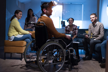 Disabiliti concept. Diverse group of architects witho one in wheelchair working in coworking office using modern technology.