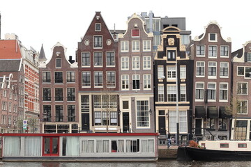 Fototapeta premium Amsterdam Amstel River View with Historical House Facades and Houseboats