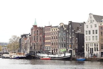 Fototapeta na wymiar Amsterdam Amstel River View with Historical House Facades and Boats
