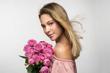 Blonde girl with a bouquet of roses flowers isolated on a gray background, Romantic Valentine's Day girl