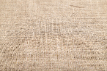 Fragment of rough linen tissue. Side view, natural textile background.