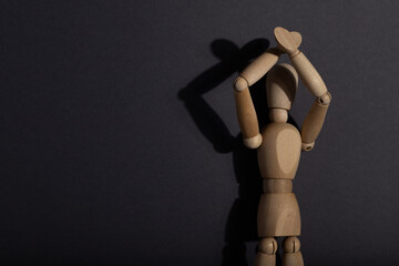 Wooden mannequin stands with raised hands on gray background. protest, attention concept. . copy...