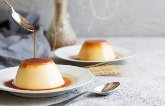 Cream caramel pudding with caramel sauce in plate on white rustic table