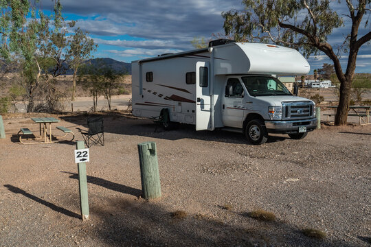 C-type camper with slideouts standing on the campground
