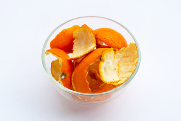 Orange peels in glass bowl on white