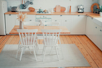 Clean kitchen. Stylish interior in the apartment under the tree and white color. Copy space. The table and chairs are vintage retro.