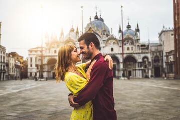 Couple of tourists visiting Venice, Italy - Boyfriend and girlfriend in love kissing on city street...