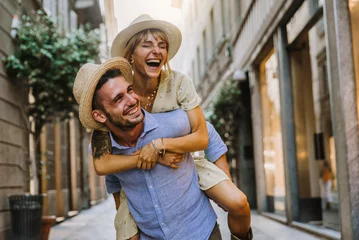 Foto op Plexiglas Een paar toeristen die plezier hebben tijdens het wandelen op straat in de stad op vakantie - Gelukkige vrienden die samen lachen op vakantie - Mensen en vakantieconcept © Davide Angelini