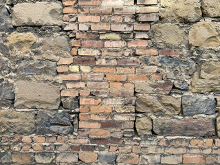 vintage fort garden wall made of block bricks cracked and covered with moss