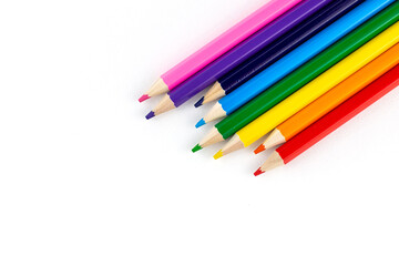 Bright colored pencils on a white paper background