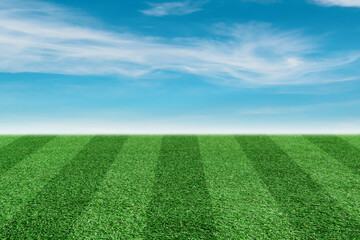 Striped grass soccer field with blue sky background.