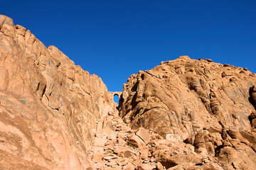 Fototapeta premium Door made of stones at the top of the mountain footpath in Mt Sinai in the Sinai desert. Egypt