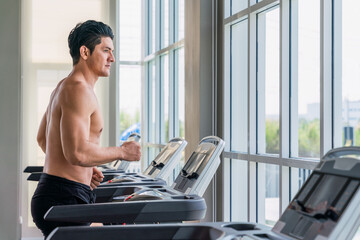 Fototapeta na wymiar athletic man doing running exercise on treadmill in gym and fitness center