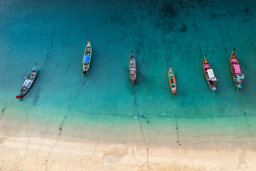 Aerial drone top down view of fishing boats in the shore during low tide. Top view a lot of Thai traditional longtail fishing boats in the tropical sea. A lot of long tail boat on sea